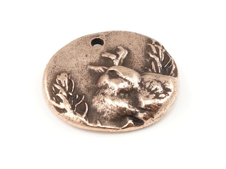 May include: A copper-colored metal charm featuring a detailed, three-dimensional design of a bird perched on a branch. The charm has a hole at the top for attaching to a necklace or bracelet.