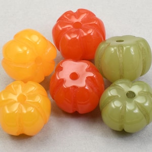 May include: A collection of six colorful, pumpkin-shaped beads. The beads are in shades of orange, yellow, and green. Each bead has a hole through the center, and the surface is smooth and glossy. These beads are ideal for jewelry making.