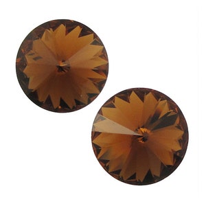 May include: Two brown crystal rhinestones with a faceted design.