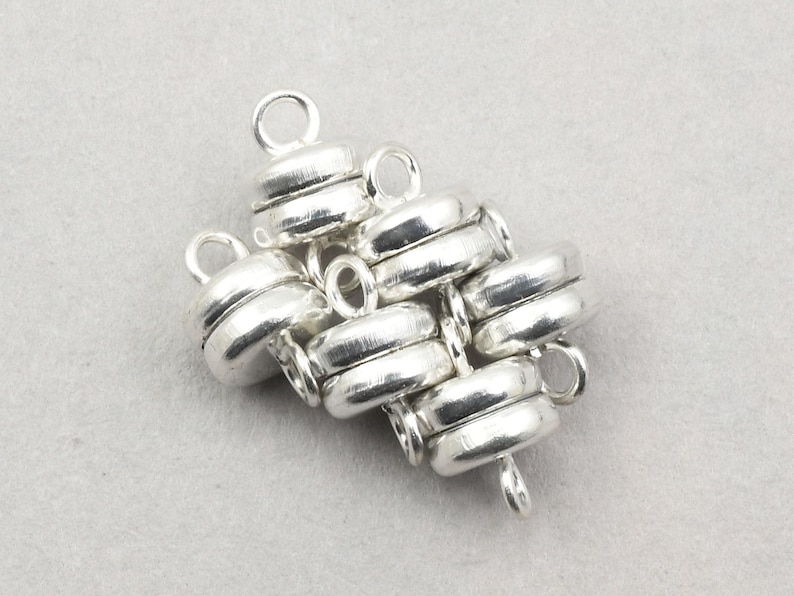May include: Silver magnetic clasp for jewelry making. The clasp is made of multiple interlocking rings, creating a unique and stylish design.