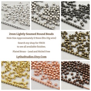 May include: Assortment of 2mm lightly seamed round beads in various metallic finishes, including silver, gunmetal, gold, and copper. The image includes text indicating the hole size is approximately 0.9mm and suitable for 22g wire. The beads are plated brass and lead/nickel free.