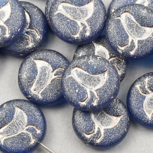May include: A collection of round, blue beads with a textured, speckled finish. Each bead features a raised, white bird design. The beads are likely for jewelry making or crafting.