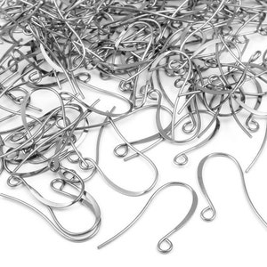 May include: A large pile of silver-toned earring hooks. The hooks are made of metal and have a simple, classic design.