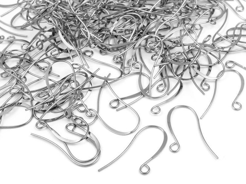 May include: A large pile of silver-toned earring hooks. The hooks are made of metal and have a simple, classic design.