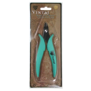 May include: A teal green wire and rivet flush cutter with a black handle. The tool is packaged in a clear plastic blister pack with a brown background. The packaging has the text "Vintage Wire and Rivet Flush Cutter" printed on it.