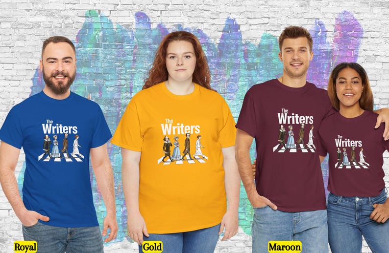 Puede incluir: Cuatro personas con camisetas azul real, doradas y granates. Cada camiseta tiene el texto "The Writers" sobre una ilustraci&oacute;n de figuras literarias cruzando un paso de cebra. El fondo es un mural colorido.