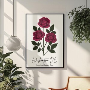 May include: A framed art print showing three deep red roses with green leaves against a white backdrop. The text "Washington D.C. American Beauty Rose" is below the floral illustration. The print is in a black frame.