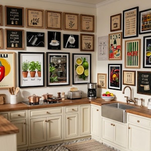 May include: A kitchen interior with various framed artworks and appliances. The wall features framed prints with text and images, including a chilli pepper, herbs, and coffee. Kitchen appliances include a toaster, coffee maker, and hob. Cream-coloured cabinets with a wooden worktop.