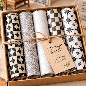 May include: A set of five rolled sheets of patterned paper in a cardboard box. The designs include black and white geometric shapes, floral motifs, and star patterns. A brown paper tag attached with twine reads 5 Design Bundle 1:12 Scale Printables.