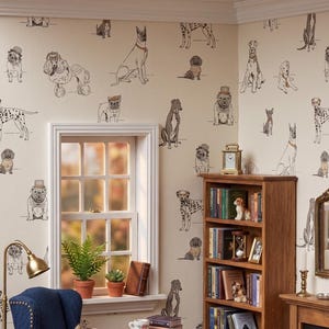 May include: A miniature room scene featuring cream-colored wallpaper with a repeating pattern of various dog breeds in black, white, and brown. The scene includes a wooden bookshelf, a blue armchair, a window with two potted plants, and a small table.