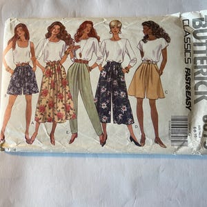 Puede incluir: Sobre de patrón de costura Butterick Classics Fast & Easy con ilustraciones de cinco mujeres con diferentes atuendos. Los atuendos incluyen pantalones cortos, faldas y pantalones con diseños florales y lisos. La talla es 6-8-10.