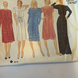 May include: Vogue Basic Design sewing pattern featuring illustrations of five different dress designs. The dresses are in various colors, including red, white, blue, and pink. The pattern number 2918 is visible.