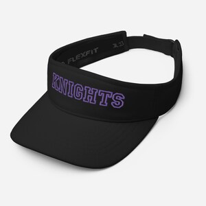 May include: Black Flexfit visor with the word "KNIGHTS" in purple block letters. The visor has a curved brim and an adjustable strap. The Flexfit logo is visible on the side.