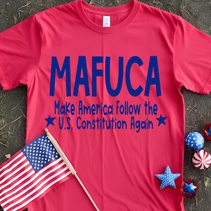 May include: Red t-shirt with blue text that reads "MAFUCA Make America Follow the U.S. Constitution Again" with a star on either side of the text.