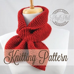 Puede incluir: Bufanda de punto roja con un nudo de lazo, en un maniquí blanco. La bufanda está hecha con un punto texturizado. La imagen incluye el texto "Comfy Cozy Phyl Phil Handknits Knitting Pattern".