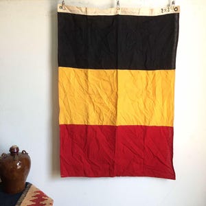 Pode incluir: Uma bandeira preta, amarela e vermelha com o texto "2 x 3" no canto superior direito.