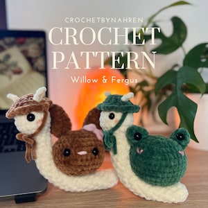 Könnte beinhalten: Häkelanleitung für zwei Amigurumi-Schnecken, eine braune mit einem Hasen auf dem Rücken und eine grüne mit einem Frosch auf dem Rücken. Die Schnecken tragen Hüte und Schals. Das Muster heißt "Willow & Fergus".