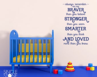 May include: A blue crib with a yellow mattress and a white wall with a blue inspirational quote that reads: "always remember - you are braver than you believe stronger than you seem smarter than you think and loved more than you know"