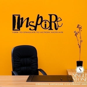 May include: Black and white wall decal with the word "Inspire" in a stylized font. The word is defined as "to stimulate to action: motivate".