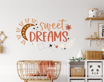 May include: A nursery wall decal with the text "Sweet Dreams" in orange and brown lettering. The decal features a crescent moon with leaves, a sun with rays, and stars in various colors.