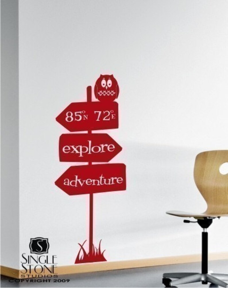 May include: Red vinyl wall decal featuring a signpost with arrows pointing in different directions. The signpost has the words "explore" and "adventure" on it. There is an owl perched on top of the signpost. The decal also includes a small patch of grass at the base of the signpost.