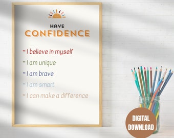 May include: A printable poster with a sun graphic and the text "HAVE CONFIDENCE" in orange and brown. The poster lists five positive affirmations: "I believe in myself", "I am unique", "I am brave", "I am smart", and "I can make a difference". The poster is framed in wood and is sitting on a white surface with a jar of colored pencils.