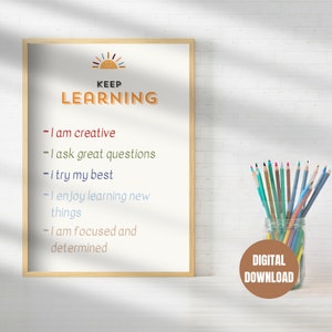 May include: A printable poster with the text "KEEP LEARNING" and a list of positive affirmations: "I am creative", "I ask great questions", "I try my best", "I enjoy learning new things", "I am focused and determined". The poster is framed in a light wood frame and is sitting on a white surface. The poster is a digital download.