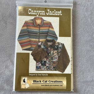 Könnte beinhalten: Eine Schnittmusterhülle mit dem Titel Canyon Jacket von Black Cat Creations. Das Cover zeigt zwei Jackenvarianten: eine mit horizontalen, mehrfarbigen Streifen und eine weitere mit einer floralen Patchwork-Vorderseite und braunen, strukturierten Ärmeln.