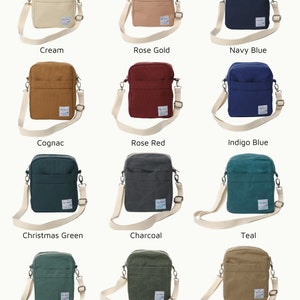 May include: A collection of crossbody bags in various colors, including cream, rose gold, navy blue, cognac, rose red, indigo blue, Christmas green, charcoal, teal, Amsterdam green, olive green, and khaki. Each bag has a matching adjustable strap.