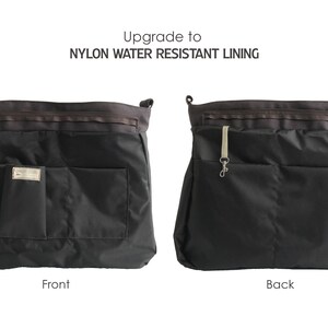 May include: A black nylon tote bag with a zipper closure and multiple pockets. The bag has a water-resistant lining. The front of the bag has a small pocket with a label. The back of the bag has a small pocket with a loop for a key chain.