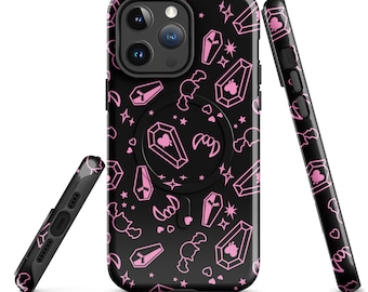 Puede incluir: Carcasa de teléfono negra con un patrón rosa y blanco de ataúdes, murciélagos y estrellas. La carcasa tiene un soporte de anillo incorporado.
