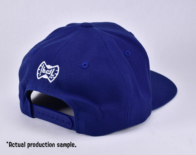 May include: A royal blue baseball cap with a white embroidered logo that says "1ball".