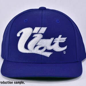 May include: A blue baseball cap with a white embroidered logo that says "Uzi" in a stylised font.