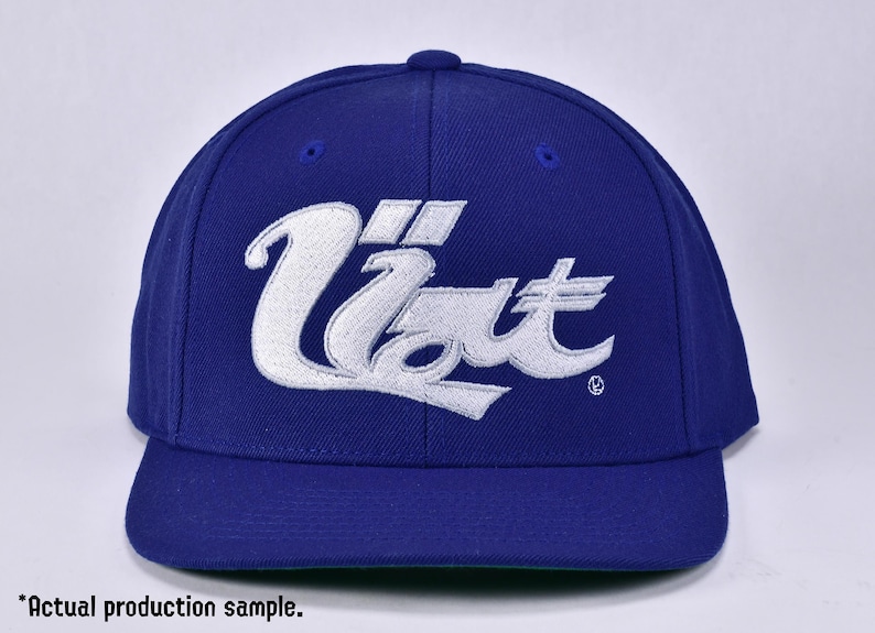 May include: A blue baseball cap with a white embroidered logo that says "Uzi" in a stylised font.