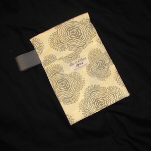 Puede incluir: Una bolsa de tela de color crema con un patr&oacute;n de espiral gris y blanco. La bolsa tiene una correa gris y una peque&ntilde;a etiqueta que dice "Lilac & Lollipop" con el sitio web "blacklilacdesigns.com".