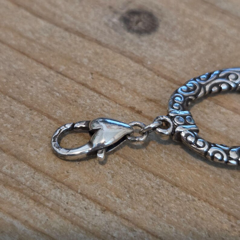 K&ouml;nnte beinhalten: Eine wei&szlig;e Keramik-Tasse mit schwarzem Henkel und dem Text "But First, Coffee" in schwarzer, fetter Schrift. Die Tasse steht auf einer wei&szlig;en Oberfl&auml;che.