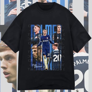 May include: Black t-shirt with a graphic design featuring a collage of images of a soccer player in a blue jersey with the text "Cole Palmer" and "20" on the shirt. The text "PALMER" is repeated vertically on the shirt.