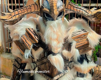 Könnte beinhalten: Ein detailliertes Cosplay-Kostüm eines Monsters mit einem großen, hölzernen Helm, einem langen, weißen Bart und einem braunen, pelzbedeckten Körper. Das Kostüm besteht aus Holz, Fell und Metall. Der Text "Yumaki monster" ist auf dem Kostüm sichtbar.