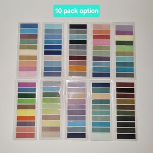 May include: Ten packs of colorful sticky notes arranged in rows. Each pack contains a gradient of colors, ranging from blues and greens to pinks and oranges. The text "10 pack option" is in a green rectangle at the top.