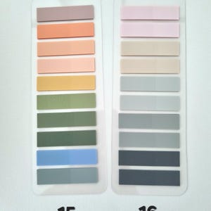 May include: Two sets of rectangular sticky notes in various pastel colors. One set is labeled "15" and includes shades of mauve, peach, pink, yellow, green, and blue. The other set, labeled "16", features pink, beige, gray, and navy blue sticky notes.
