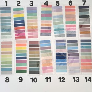May include: A collection of fourteen color swatch sets, each containing multiple rectangular sticky notes in various shades. The color palettes range from pastel to vibrant, including blues, greens, pinks, and oranges. The sticky notes are arranged in clear plastic packaging.