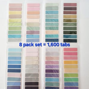 May include: Eight packs of sticky note tabs in various pastel colors, including pink, yellow, green, and blue. Each pack contains multiple tabs, with the text "8 pack set = 1,600 tabs" visible.