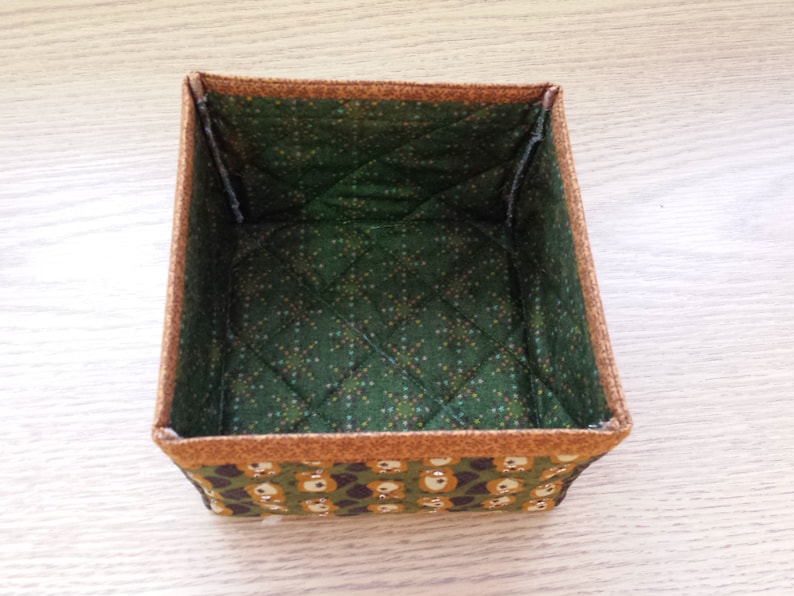 May include: A green and brown fabric storage box with a quilted interior and a pattern of small bears on the exterior.
