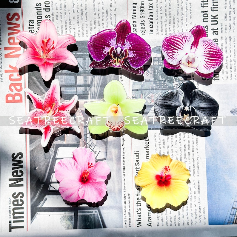 May include: Assorted artificial flower decorations in various colors, including pink, purple, yellow, and green. The flowers are arranged on a newspaper background. The text "Times News" is visible.