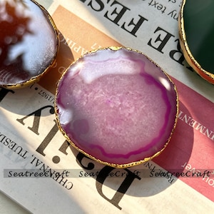 May include: A circular purple agate slice coaster with a polished, translucent surface and a textured, crystalline centre. The edges are trimmed with a metallic gold finish. The text SeatreeCraft is printed across the bottom of the image.