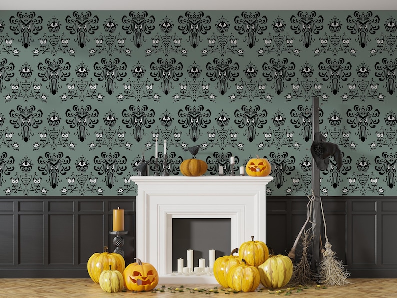May include: A room decorated for Halloween with a green and black wallpaper featuring a repeating pattern of a ghost's face. A white fireplace with a black mantel is decorated with candles and pumpkins. A black broom leans against the wall.