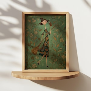 Könnte beinhalten: Gerahmter Kunstdruck mit einer skurrilen Illustration einer Frau in einem Blumenkleid, die einen Besen und eine Kaffeetasse hält. Das Kunstwerk hat einen grünen floralen Hintergrund und wird auf einem Holzregal präsentiert.
