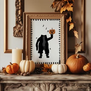 May include: A framed Halloween print depicting a headless figure with a pumpkin. The artwork is in a wooden frame, surrounded by pumpkins, autumn leaves, and a candle. The colour scheme includes black, orange, and cream.