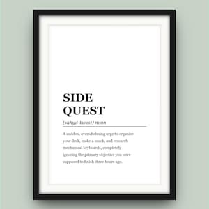 Puede incluir: Impresión enmarcada con las palabras "SIDE QUEST" en negrita, fuente negra. La definición describe un impulso repentino de organizar, comer bocadillos e investigar, ignorando el objetivo principal. La impresión está en un marco negro.