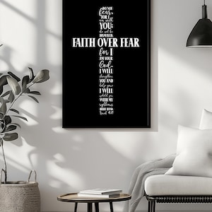 May include: A framed black and white print featuring a cross design with the words "FAITH OVER FEAR" in large letters. The print includes a Bible verse, "Do not fear, for I am with you; do not be dismayed." The artwork is displayed on a white wall.